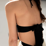 Produkte werden am Model von der Rückseite gezeigt. Zu sehen sind die schwarzen Seidenbänder von Bralette und Strapsgürtel