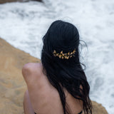 Moderne Göttin guckt auf das Meer und man sieht die Schnürung des Bodys Dessous von hinten