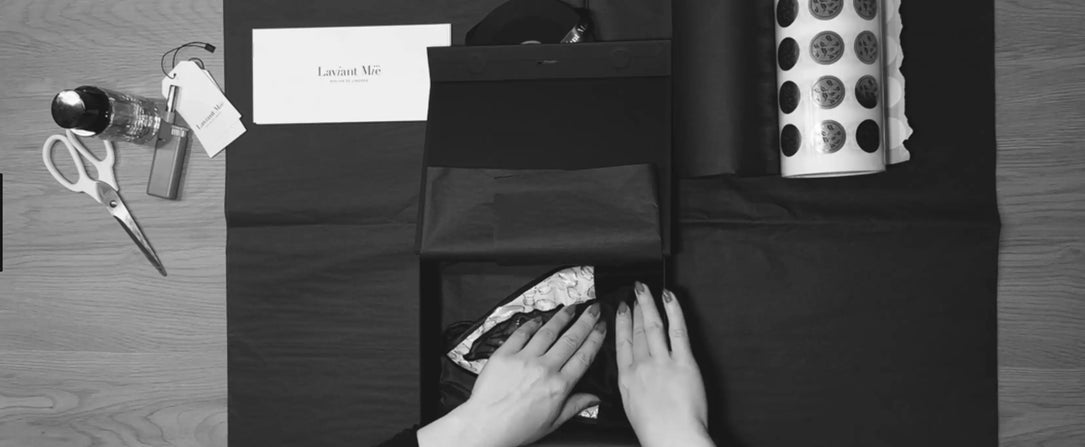 Hände falten schwarzes Seidenpapier in einer luxuriösen Laviant Mië Geschenkbox – Sinnbild für handgefertigte Haute Lingerie, Liebe zum Detail und Slow Luxury