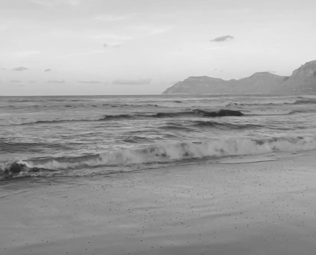 Schwarzes und weißes Strandvideo, das für die fließende Energie, Anziehungskraft und Eleganz der Laviant Mië Modern Goddess steht.